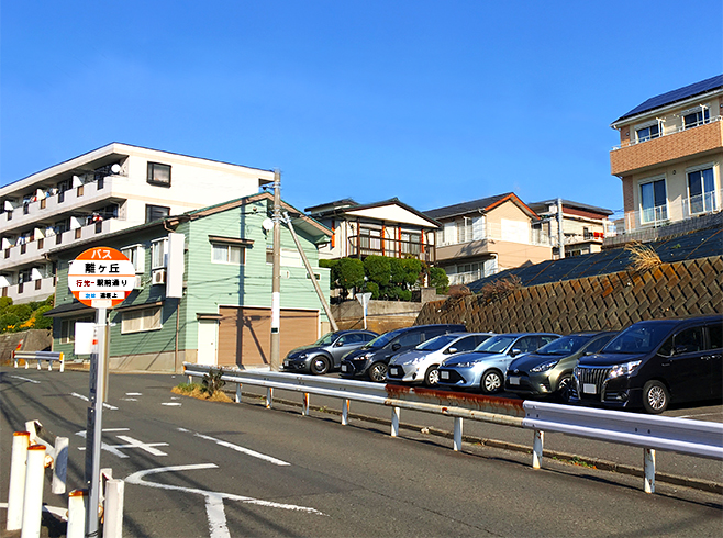 バス停越しに見える駅から離れた住宅地の画像